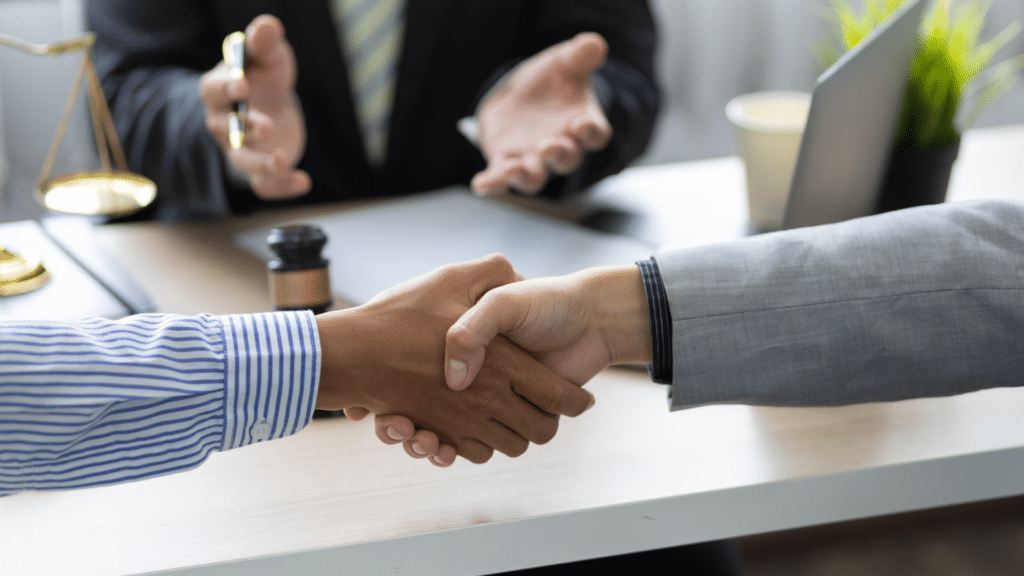 שני ידיים לוחצות בחדר של מגשר